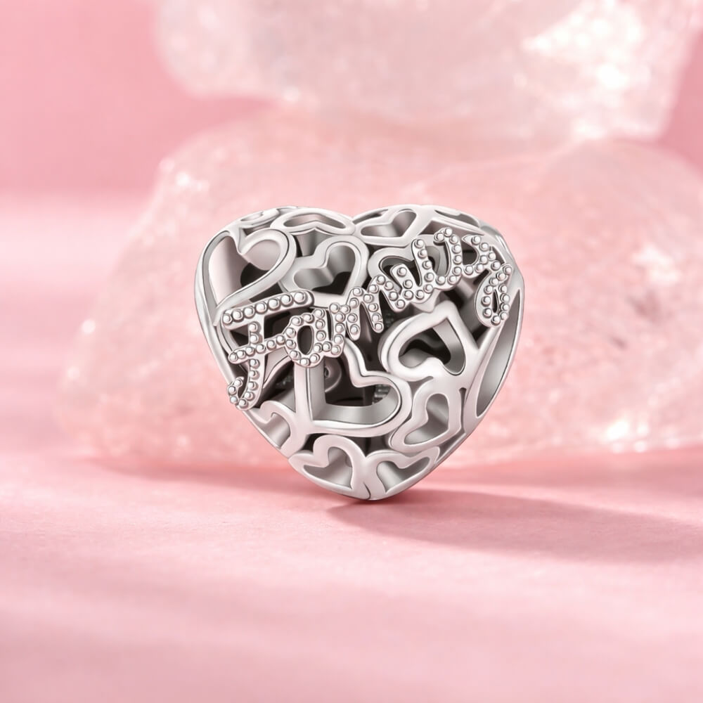 Sterling silver heart charm with Family text and cutout hearts.