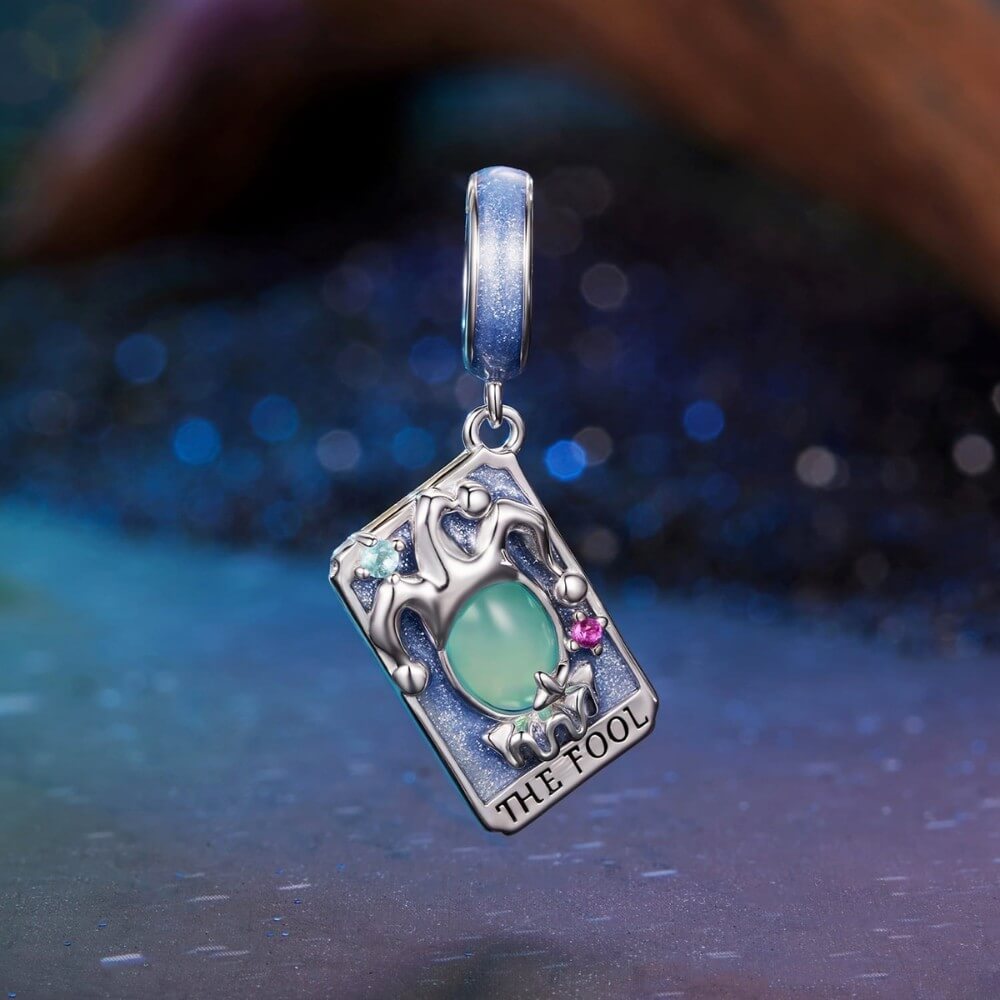 Sterling silver tarot charm with green crystal and blue enamel details.
