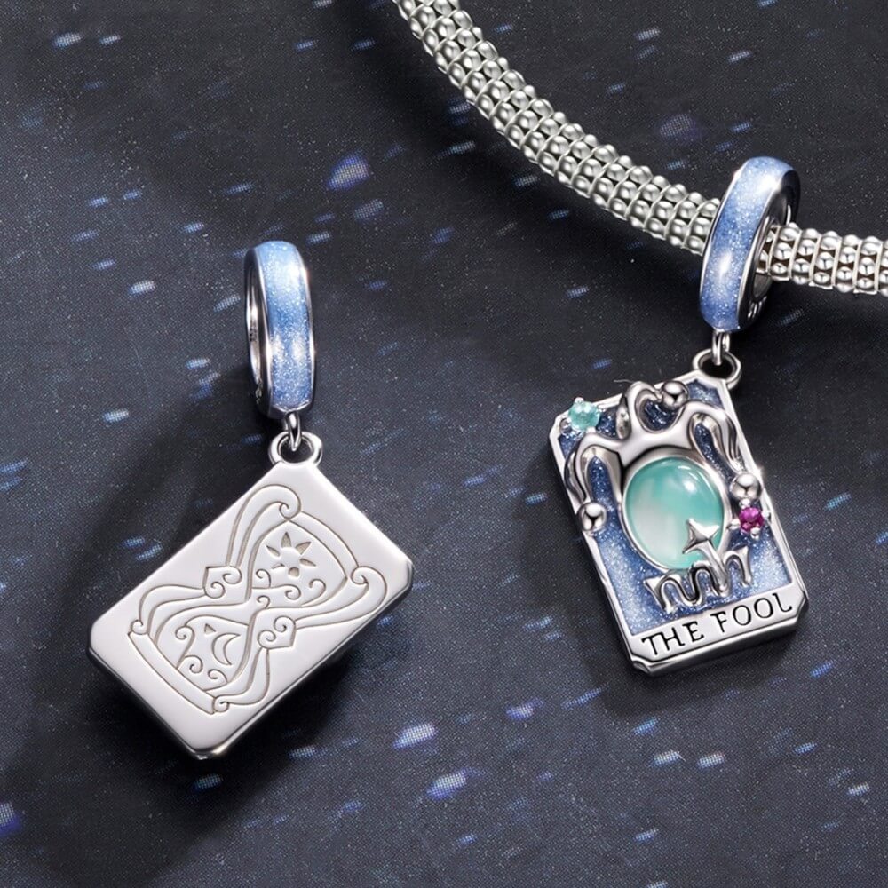 Sterling silver tarot charm with green crystal and blue enamel details.