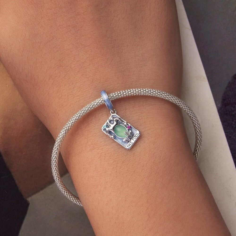 Sterling silver tarot charm with green crystal and blue enamel details.