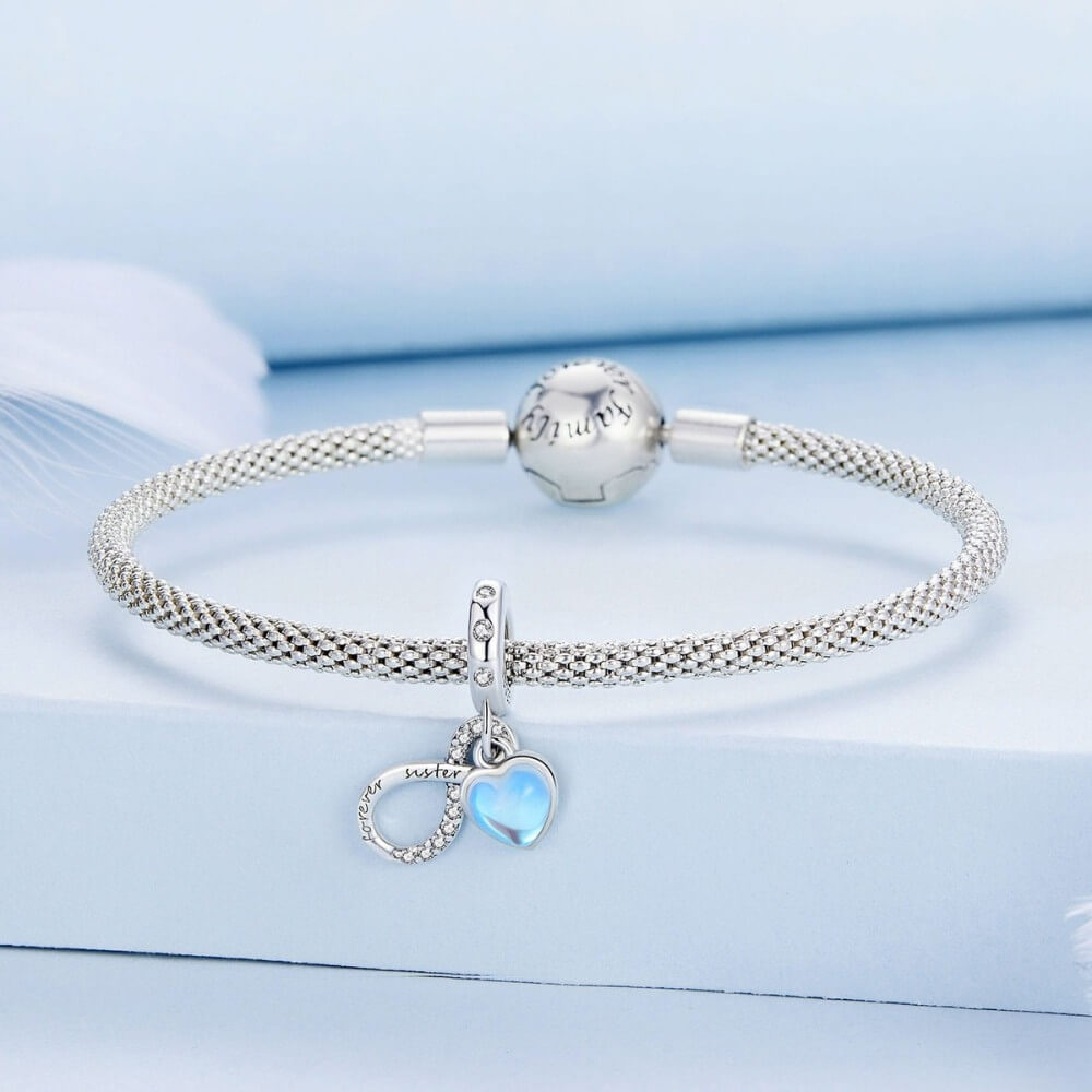 Sterling silver forever sister charm with blue heart and crystal infinity detail.