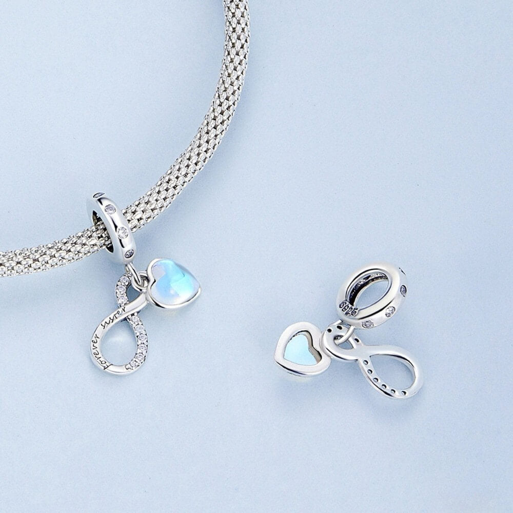 Sterling silver forever sister charm with blue heart and crystal infinity detail.