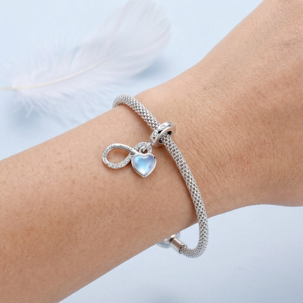 Sterling silver forever sister charm with blue heart and crystal infinity detail.