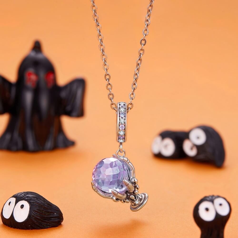 Sterling silver fortune teller charm with lavender crystal ball and skeletal hand.