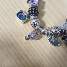 Sterling silver fortune teller charm with lavender crystal ball and skeletal hand.