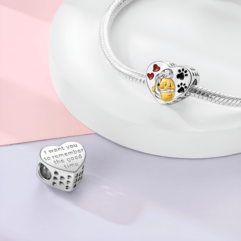 Sterling silver heart charm with gold-tone dog hugging a person, red hearts, and black paw prints