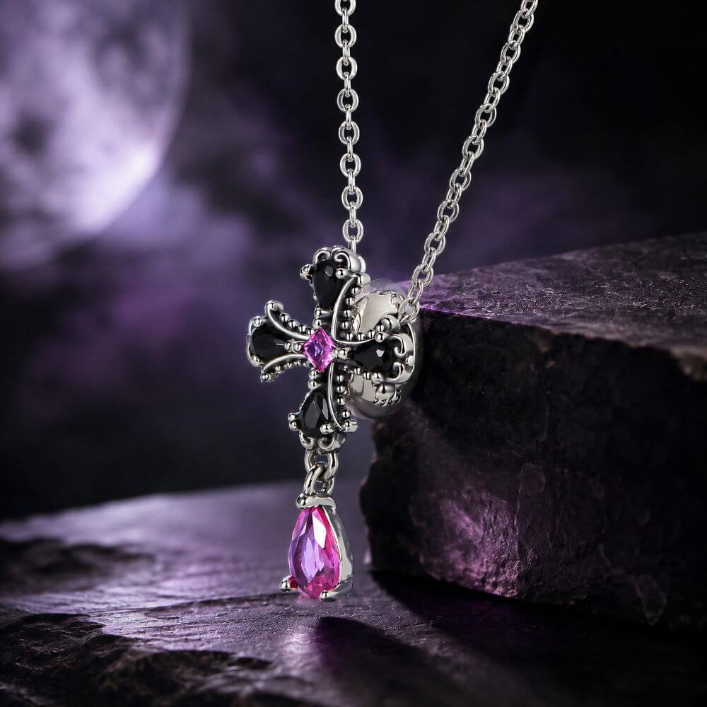 Sterling silver gothic cross charm with black crystals, pink center stone, and dangling magenta crystal drop.
