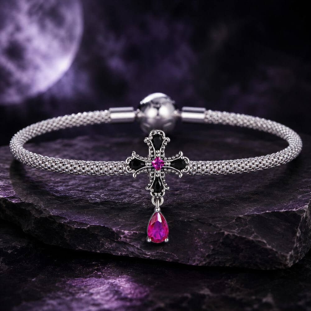 Sterling silver gothic cross charm with black crystals, pink center stone, and dangling magenta crystal drop.