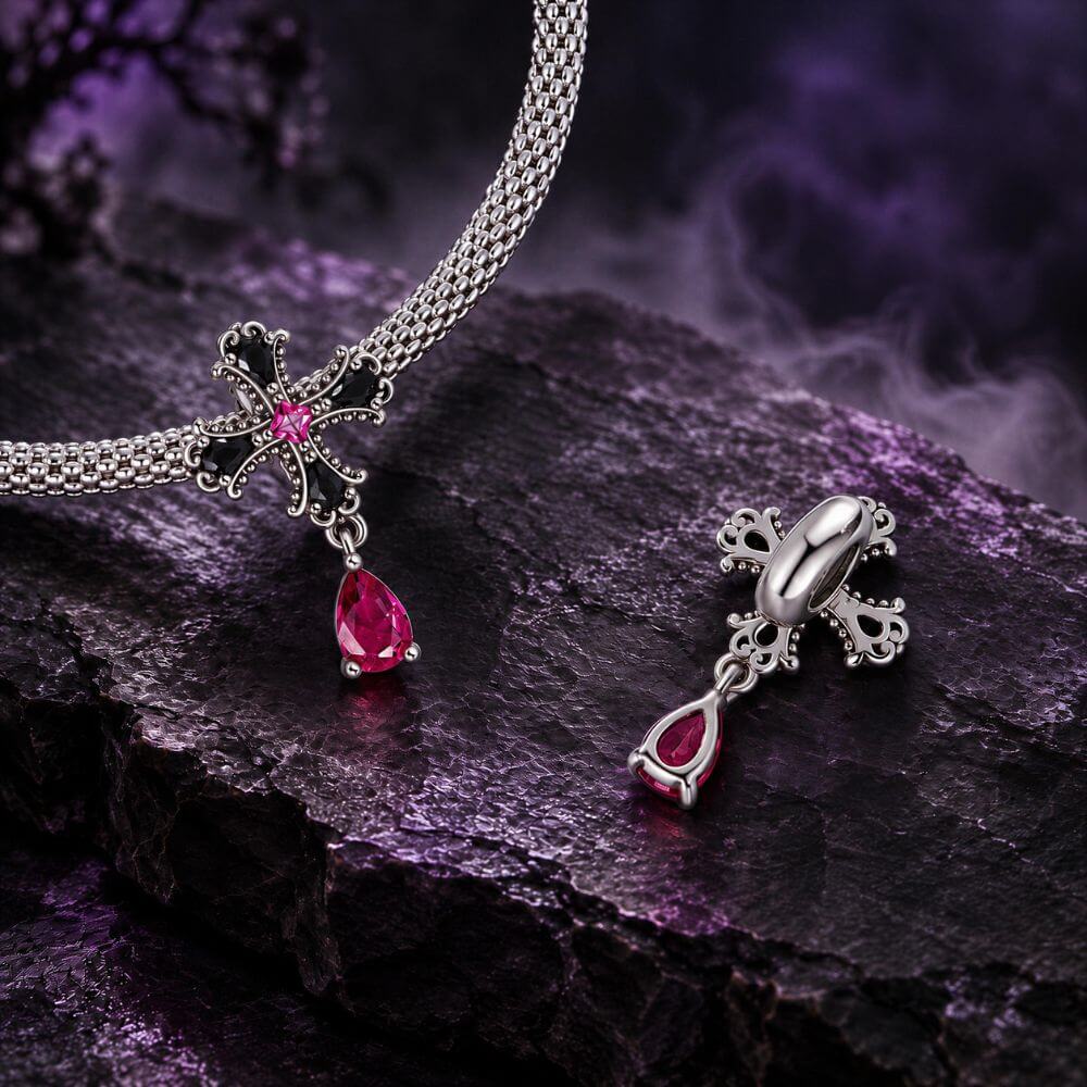 Sterling silver gothic cross charm with black crystals, pink center stone, and dangling magenta crystal drop.