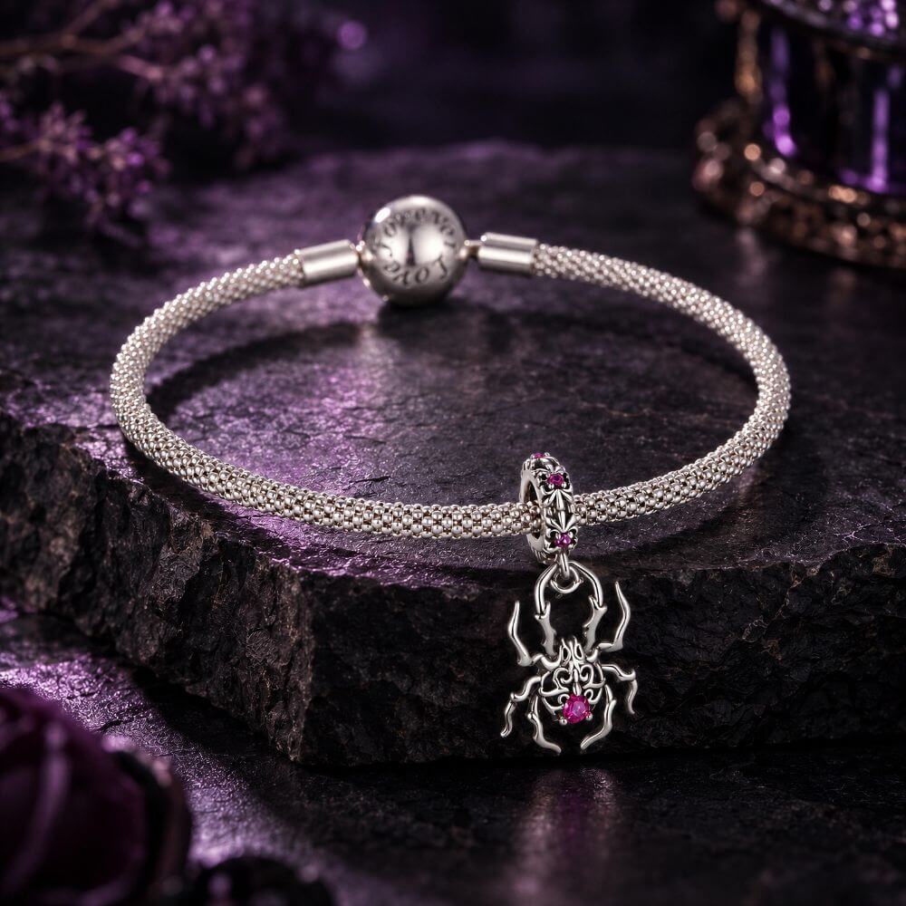 Sterling silver spider charm with gothic web details, pink crystals, and an ornate dangling body design.