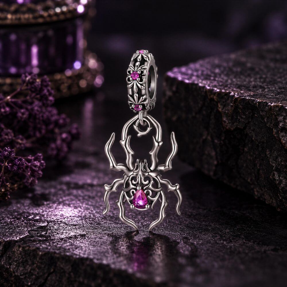 Sterling silver spider charm with gothic web details, pink crystals, and an ornate dangling body design.