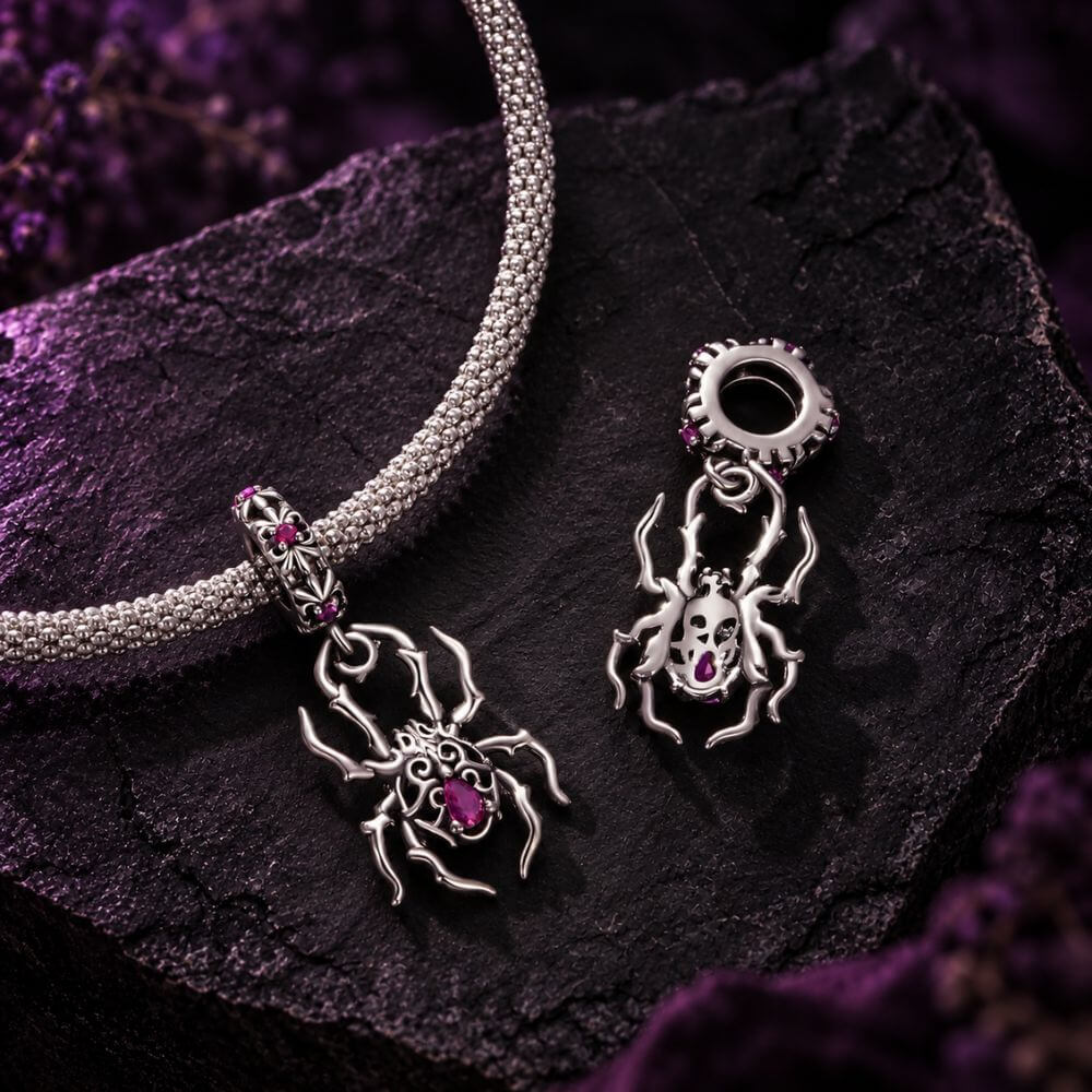 Sterling silver spider charm with gothic web details, pink crystals, and an ornate dangling body design.