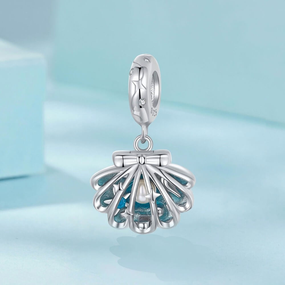 Sterling silver shell charm with hidden pearl and ocean blue enamel.