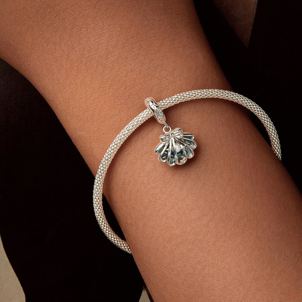 Sterling silver shell charm with hidden pearl and ocean blue enamel.