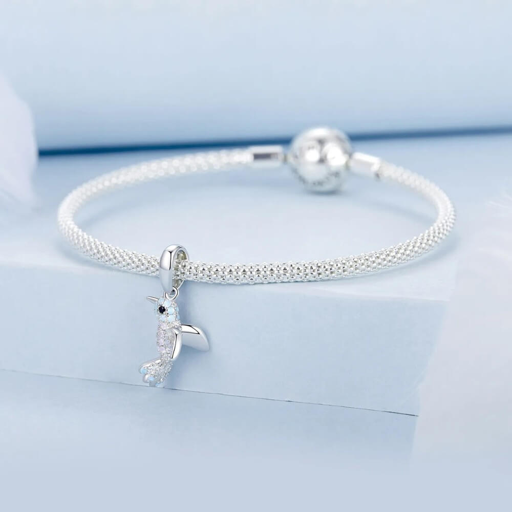 Sterling silver hummingbird charm with blue opal stones and crystal details.