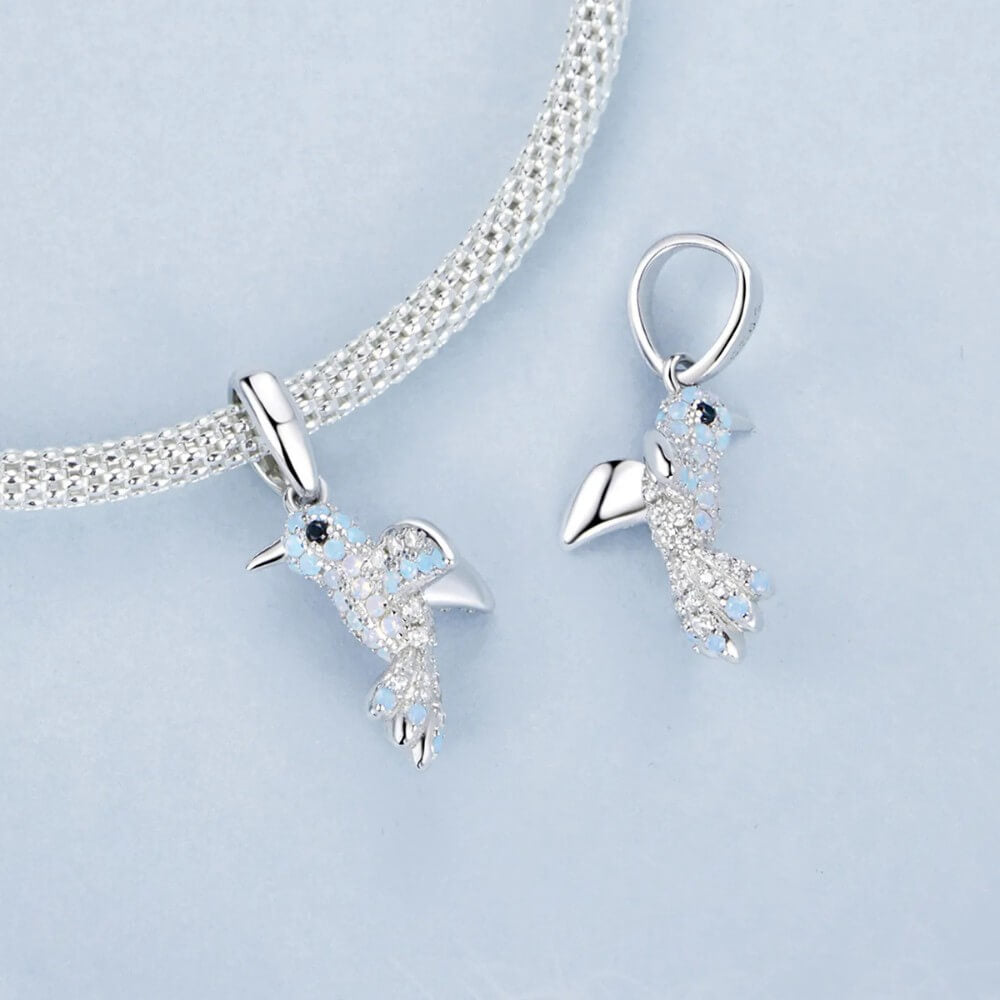 Sterling silver hummingbird charm with blue opal stones and crystal details.