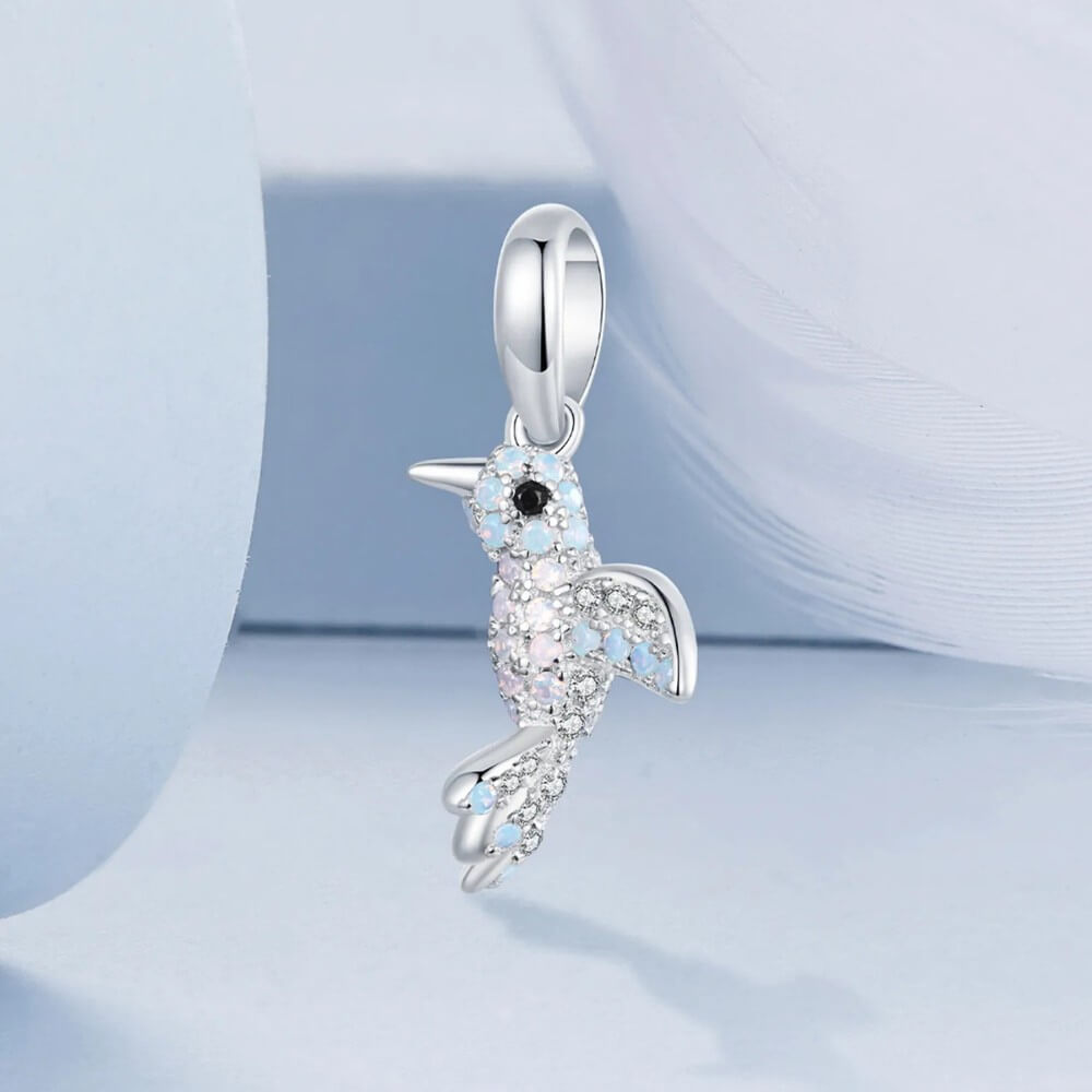 Sterling silver hummingbird charm with blue opal stones and crystal details.