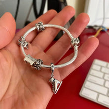 Sterling silver ice skate charm with blue crystal details and winter sparkle.