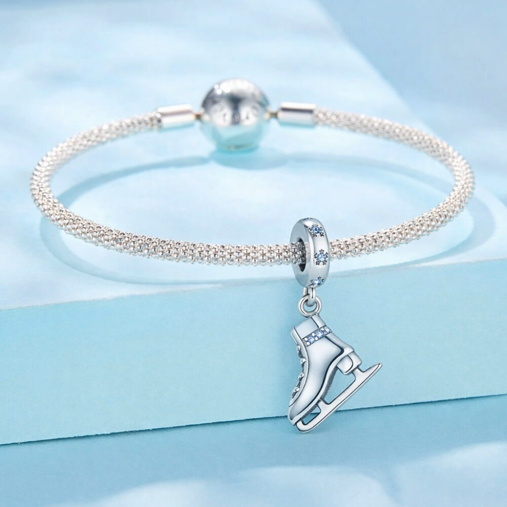 Sterling silver ice skate charm with blue crystal details and winter sparkle.