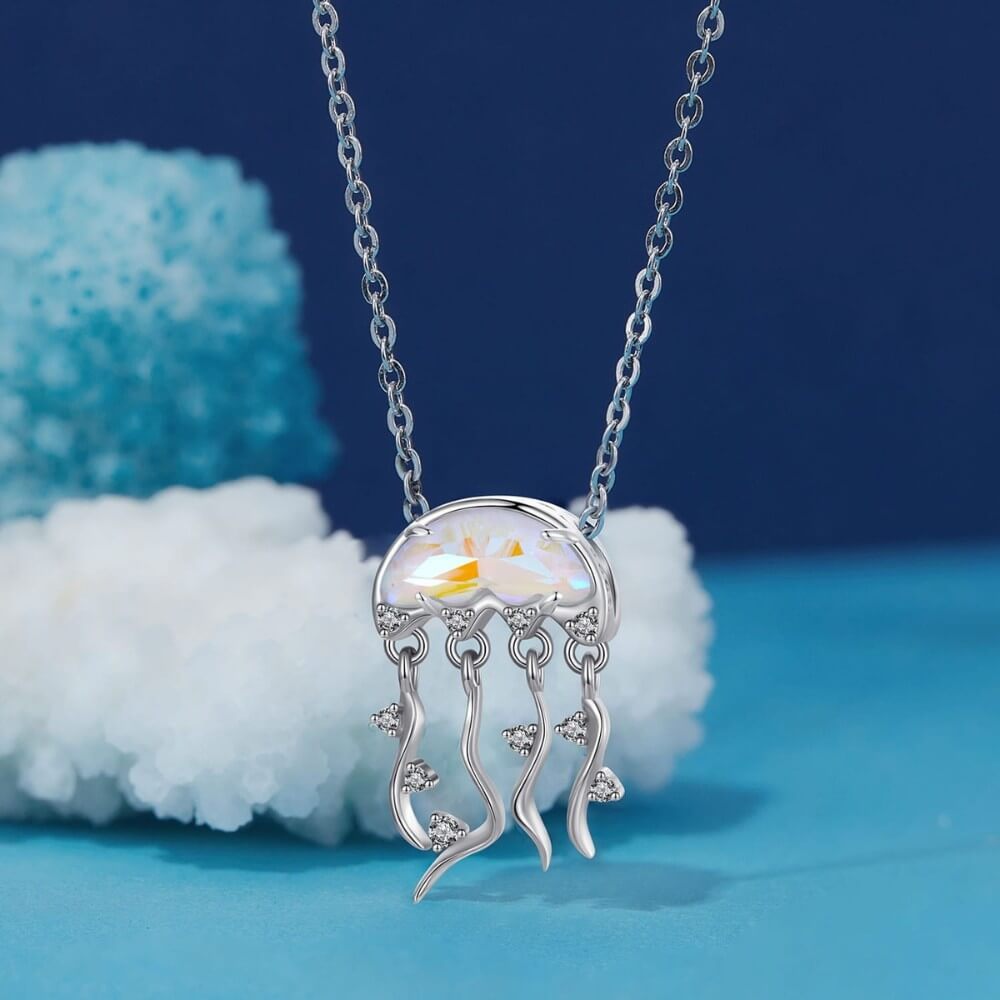Sterling silver jellyfish charm with iridescent crystal and flowing tentacle details.
