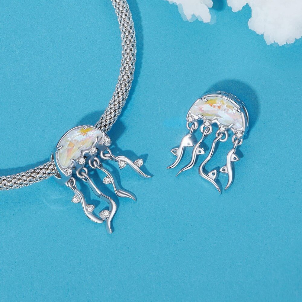 Silver jellyfish-shaped charms on a blue background