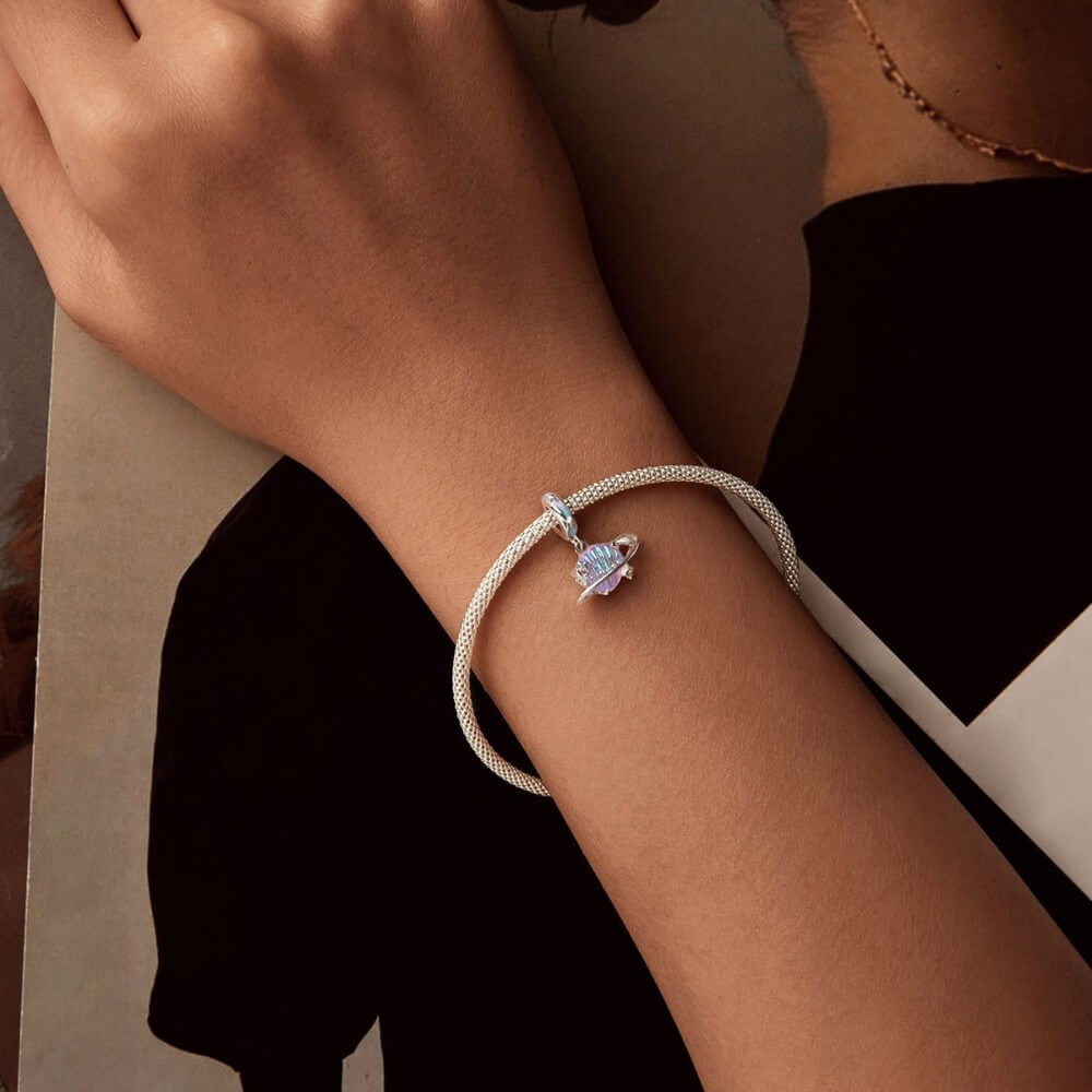 Sterling silver planet charm with iridescent shell design and star accents.