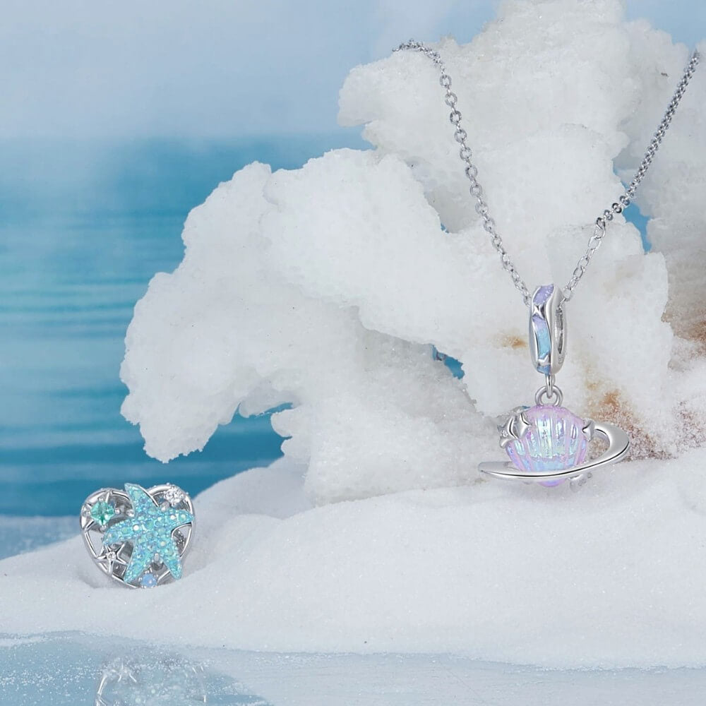 Sterling silver planet charm with iridescent shell design and star accents.