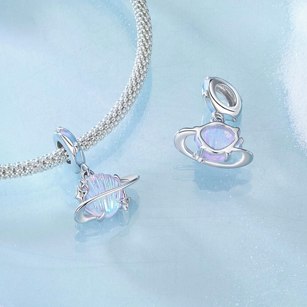 Sterling silver planet charm with iridescent shell design and star accents.