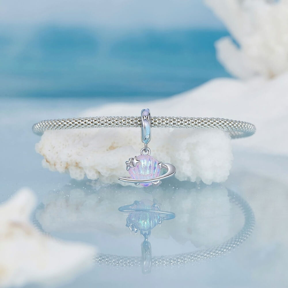 Sterling silver planet charm with iridescent shell design and star accents.