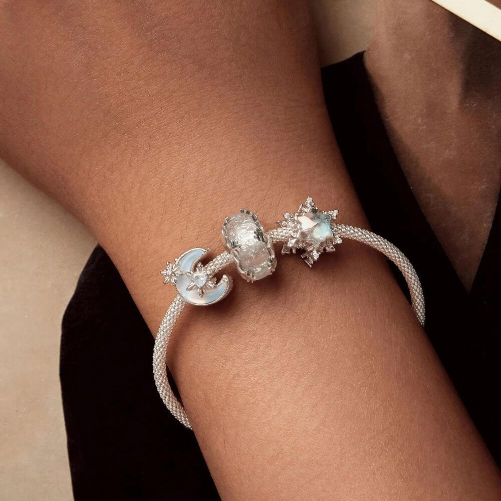 Sterling silver snowflake charm with iridescent crystal center and sparkling clear crystal accents.