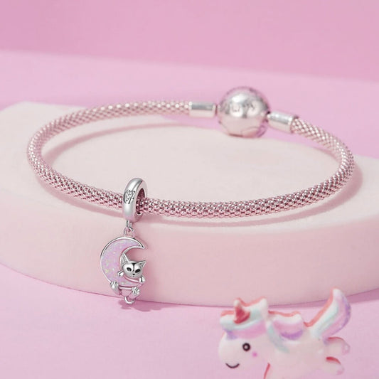 Sterling silver kitten charm with pink opal moon and star detail.