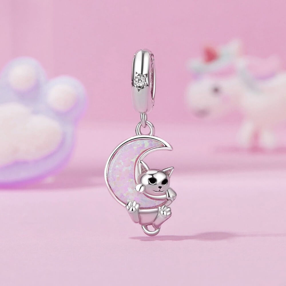 Silver cat charm on a moon with a pink background