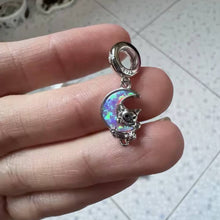 Sterling silver kitten charm with pink opal moon and star detail.