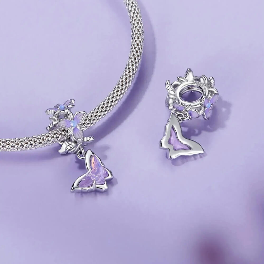 Sterling silver butterfly charm with lavender crystal and floral details.