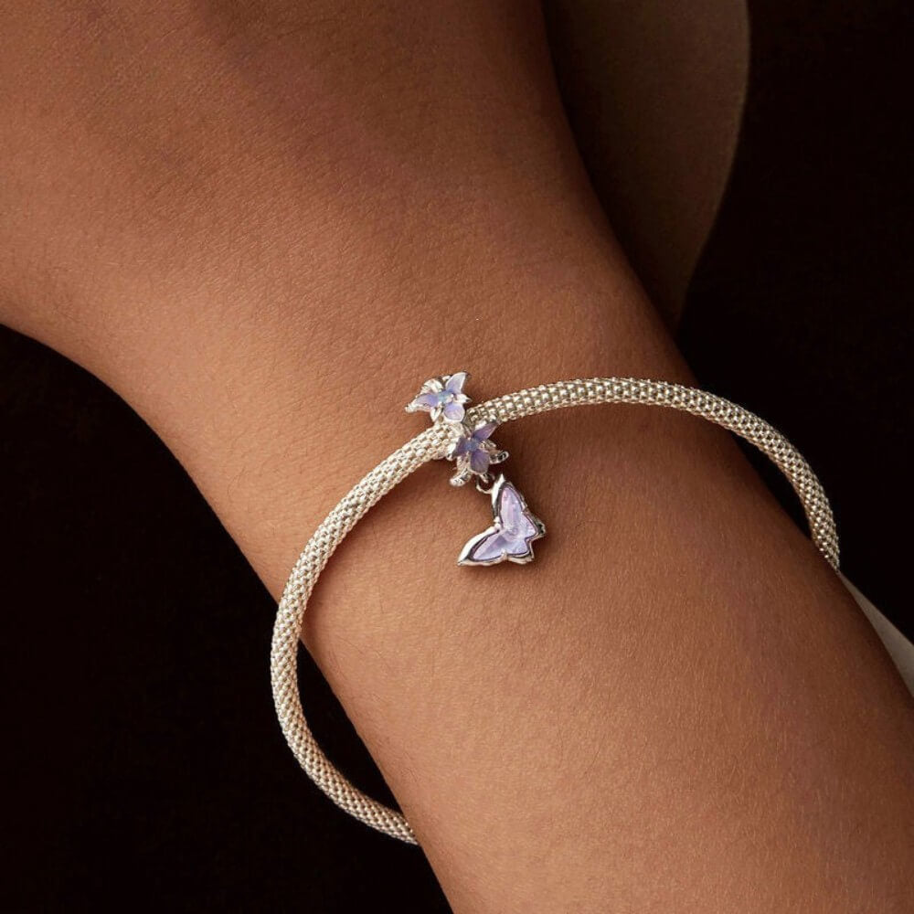 Sterling silver butterfly charm with lavender crystal and floral details.