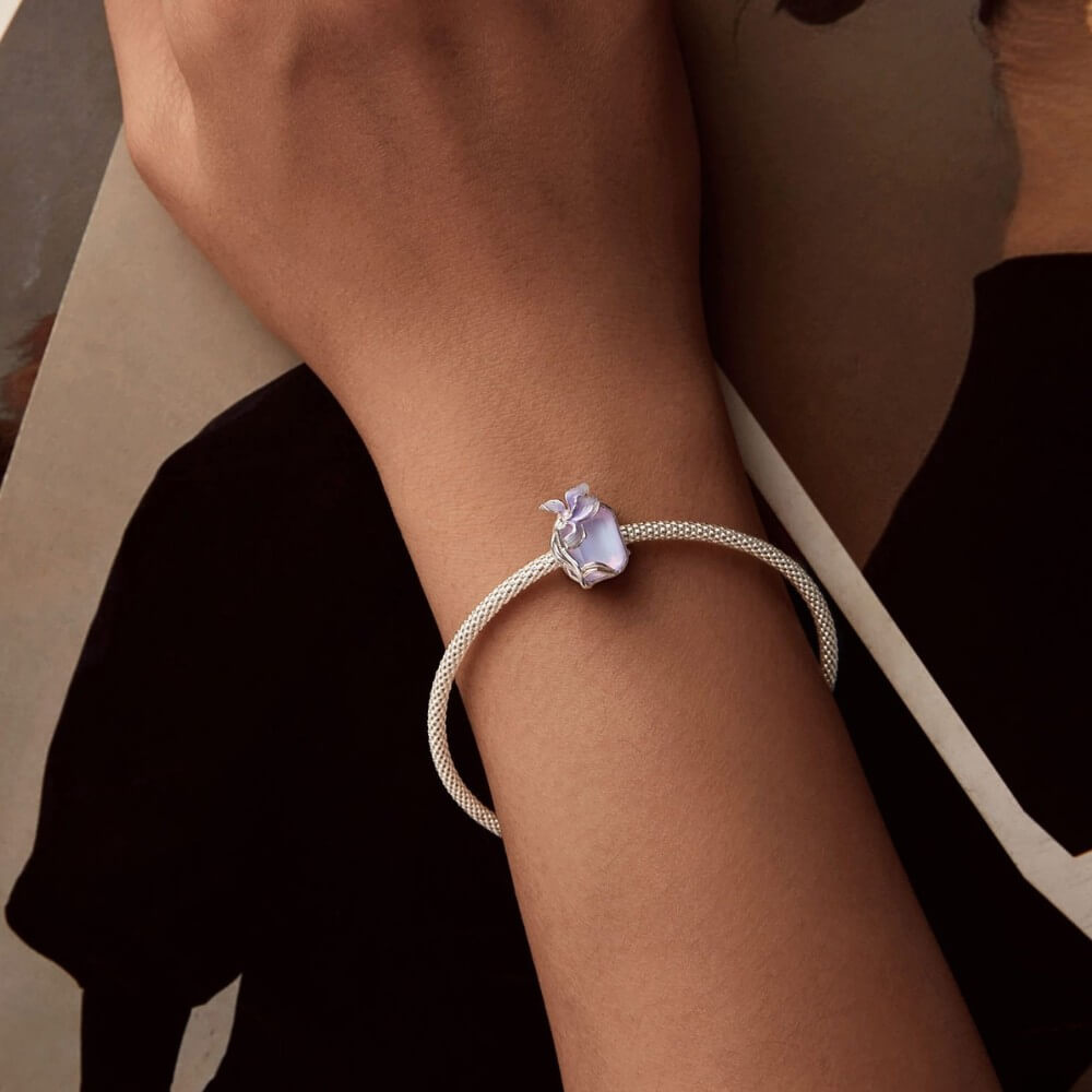 Sterling silver crystal charm with lavender flower and iridescent stone.
