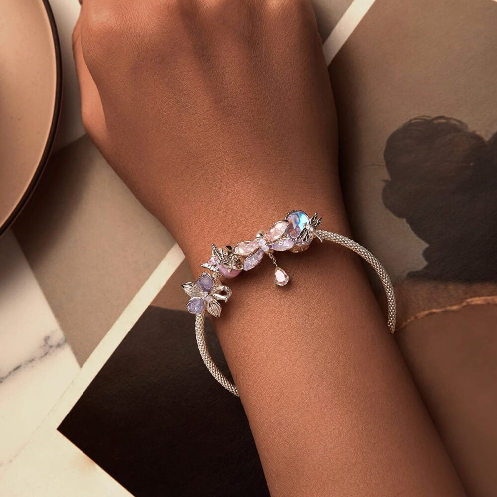 Sterling silver flower charm with lavender petals and iridescent crystal details.