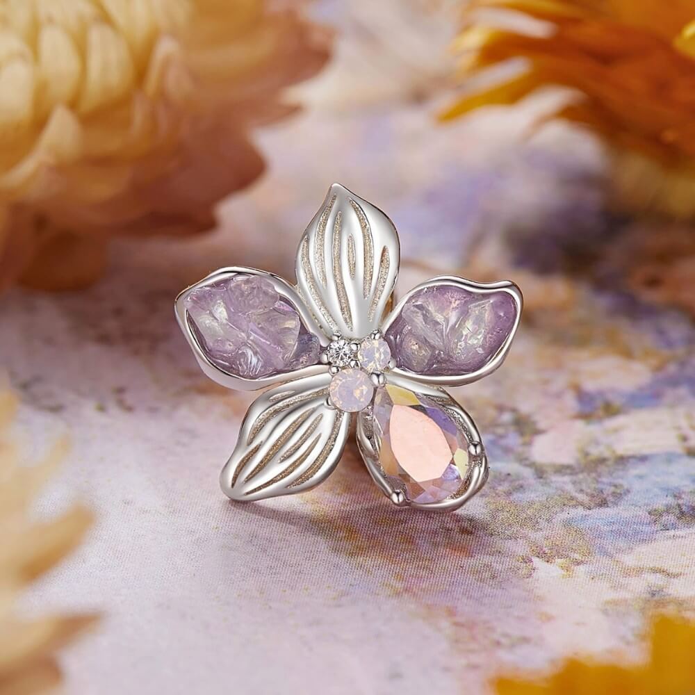 Sterling silver flower charm with lavender petals and iridescent crystal details.