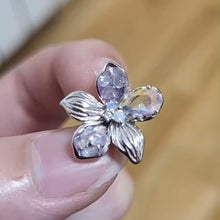 Sterling silver flower charm with lavender petals and iridescent crystal details.