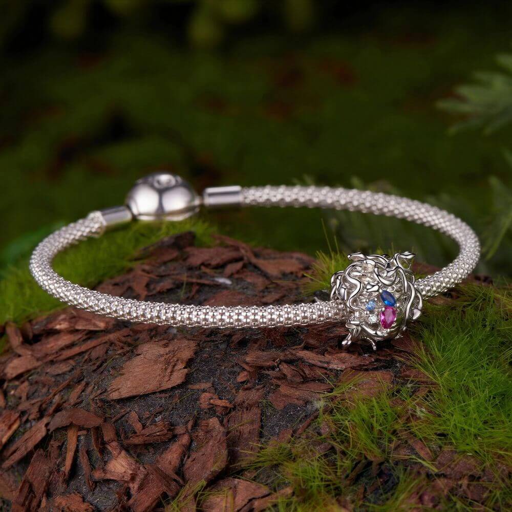 Sterling silver Medusa charm with sculpted snake hair and vivid pink, blue, and clear crystal details.