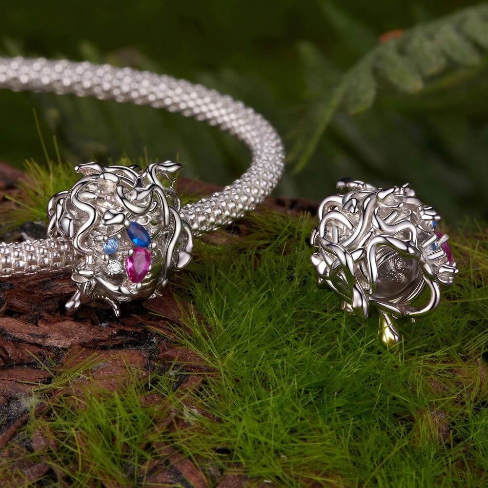 Sterling silver Medusa charm with sculpted snake hair and vivid pink, blue, and clear crystal details.