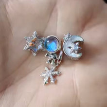 Sterling silver moon charm with iridescent enamel and floral crystal details.