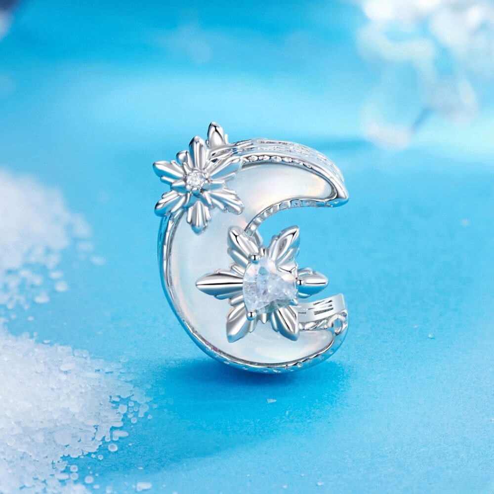 Sterling silver moon charm with iridescent enamel and floral crystal details.