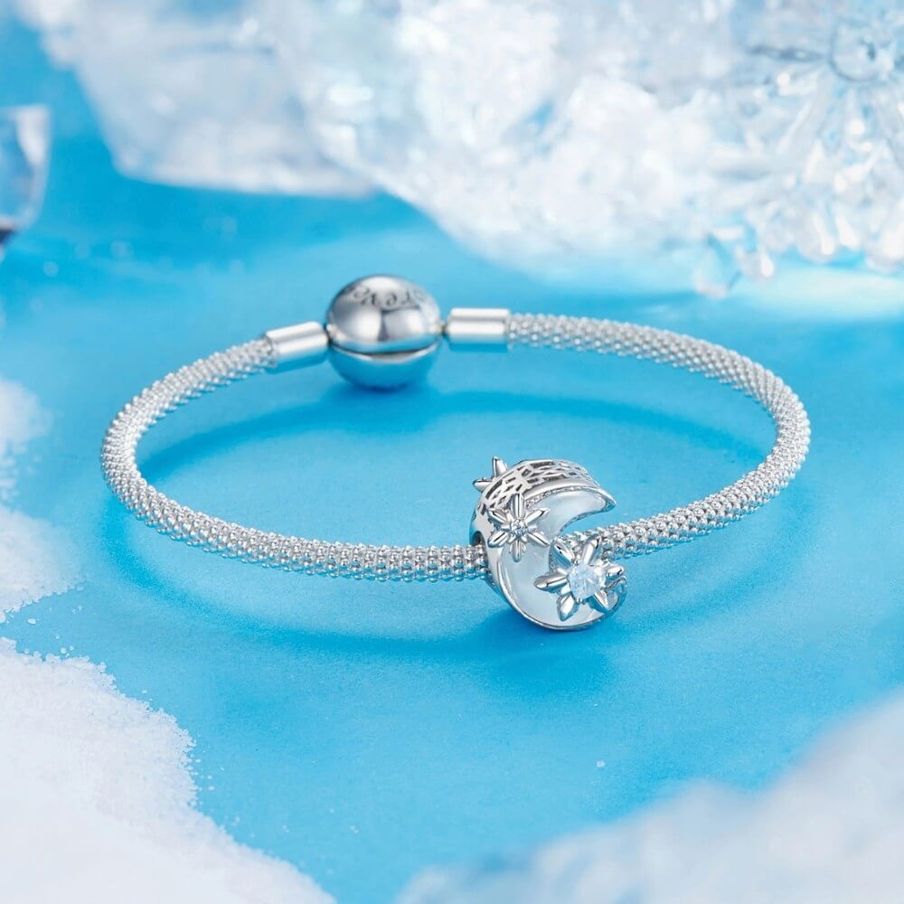 Sterling silver moon charm with iridescent enamel and floral crystal details.