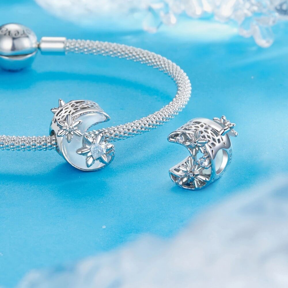 Sterling silver moon charm with iridescent enamel and floral crystal details.