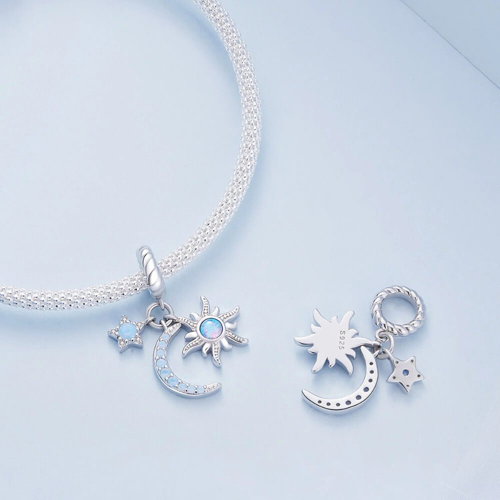 Sterling silver moon charm with sun, star, and blue opal details.