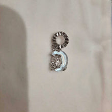 Sterling silver unicorn charm on moon with opalescent glow.
