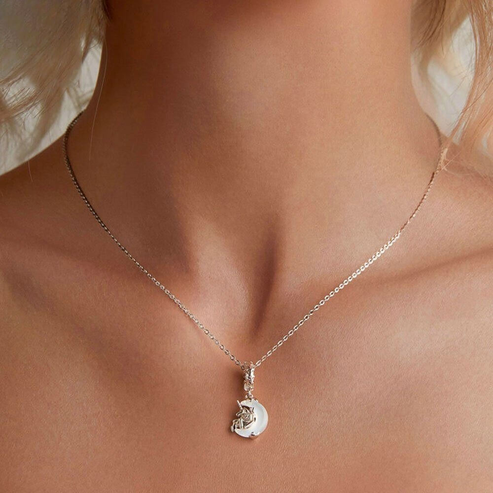 Sterling silver unicorn charm on moon with opalescent glow.