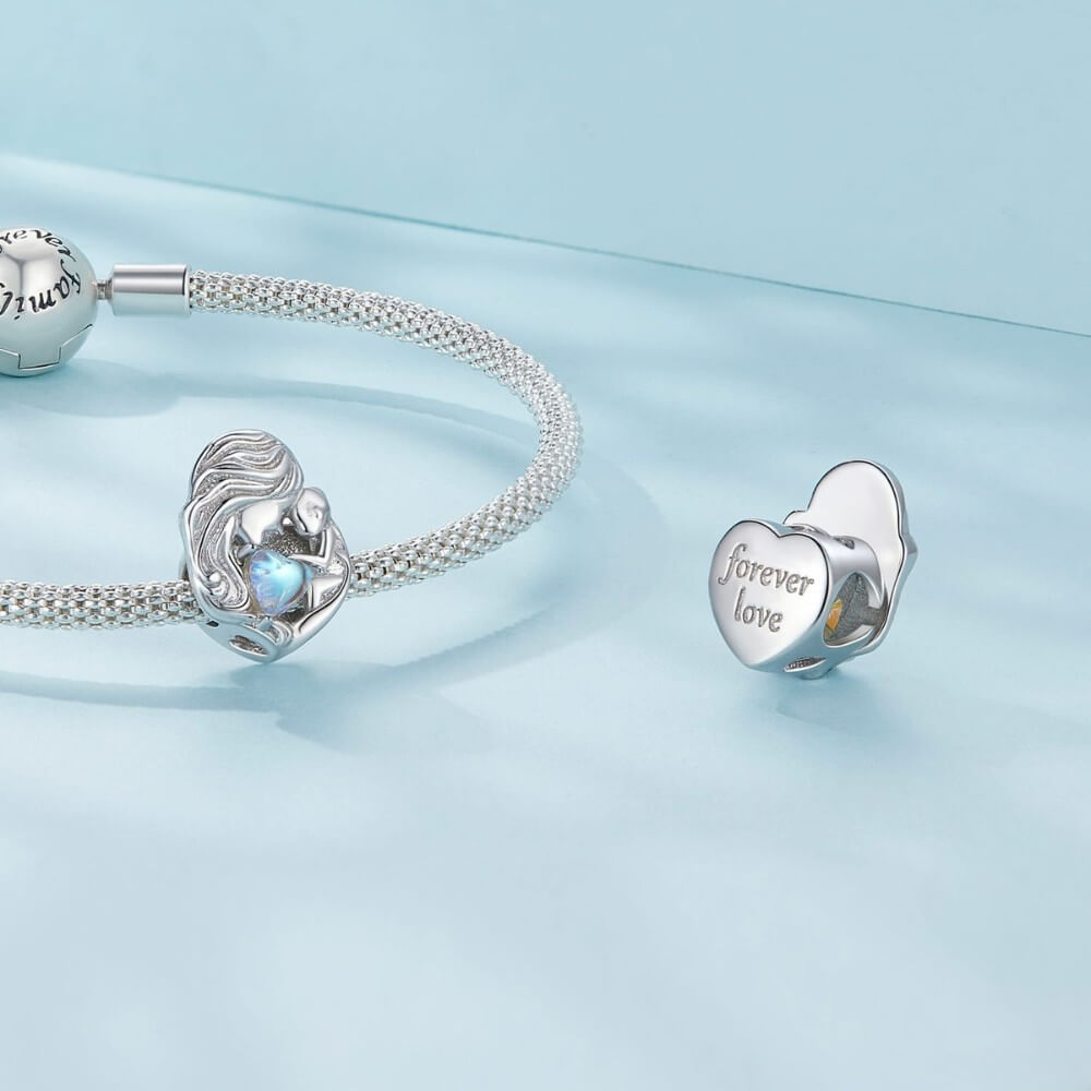 Sterling silver mother and baby charm with iridescent heart detail.