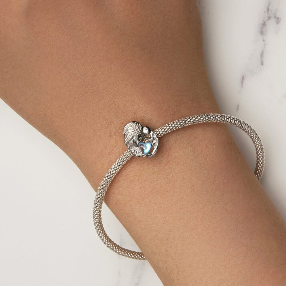 Sterling silver mother and baby charm with iridescent heart detail.